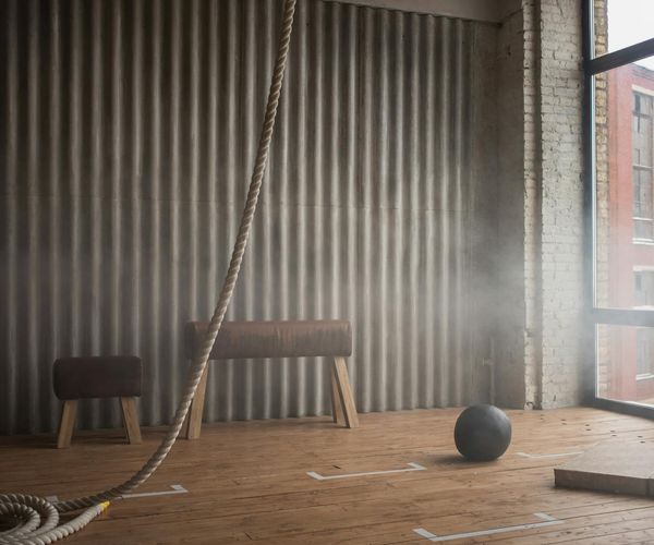 Minimalist training space with natural sunlight and wooden floor.
